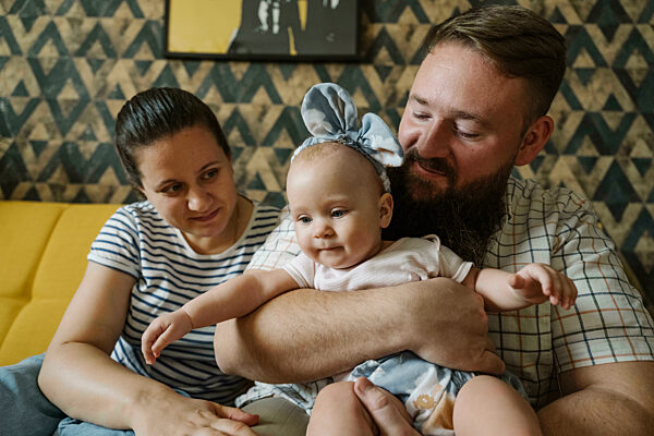 Mother and father looking at cute daughter wearing headband