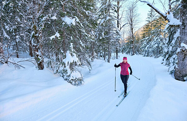 Senior woman with ski pole skiing in snow on vacation