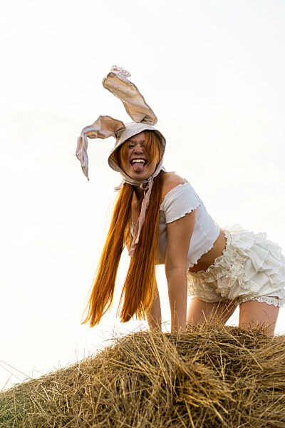 Playful young woman wearing rabbit costume showing tongue