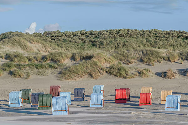 Germany, Lower Saxony, Juist, Hooded beach chairs in front of grassy dunes