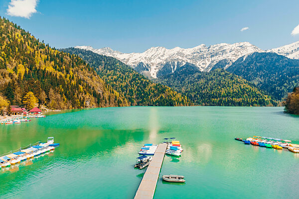 Boats moored by jetty at Lake Ritsa on sunny day