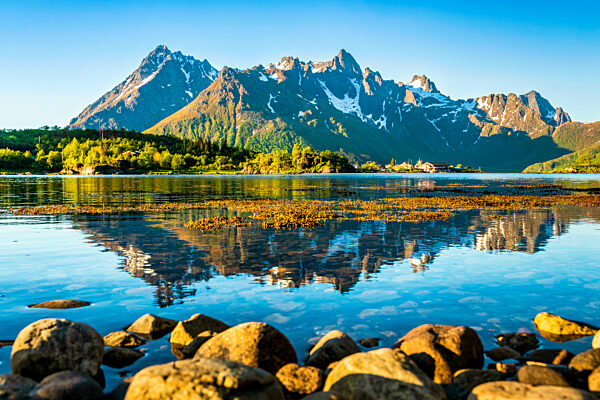 Norway, Nordland, Coastline of Austnesfjorden with mountains in background
