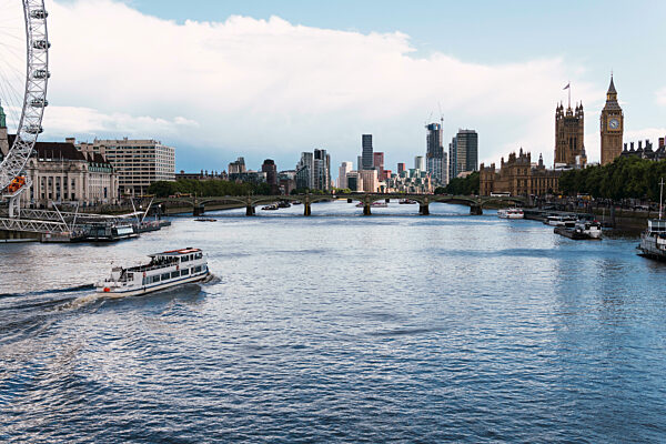 Boat on Thames River with London skyline, England