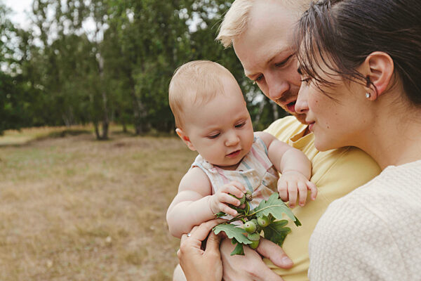 Mother and father playing with daughter in park