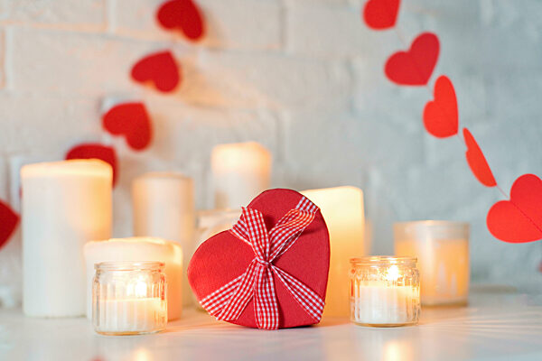 Heart shaped gift box with candles on table