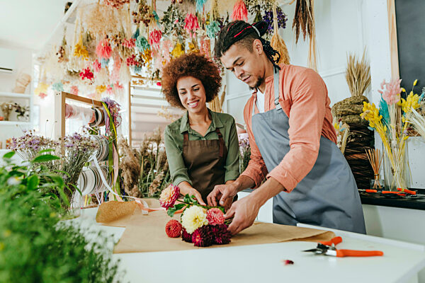 Store owners making flower bouquet at desk