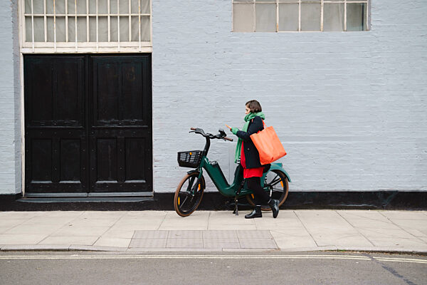 Woman walking on sidewalk in front of building