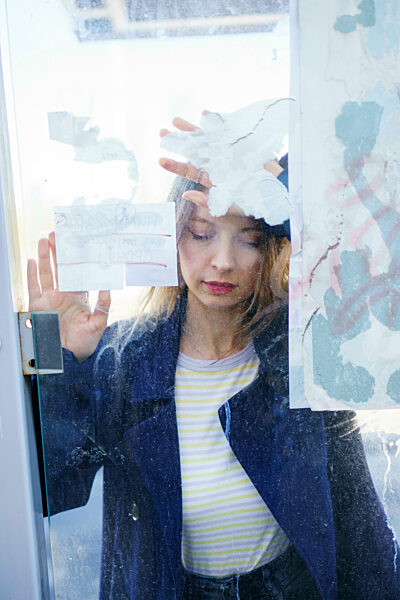 Sad woman leaning on glass window