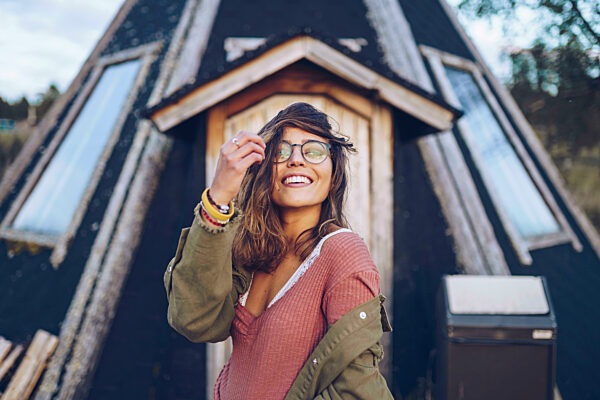 Portrait of a laughing young woman infront of a Finnish house