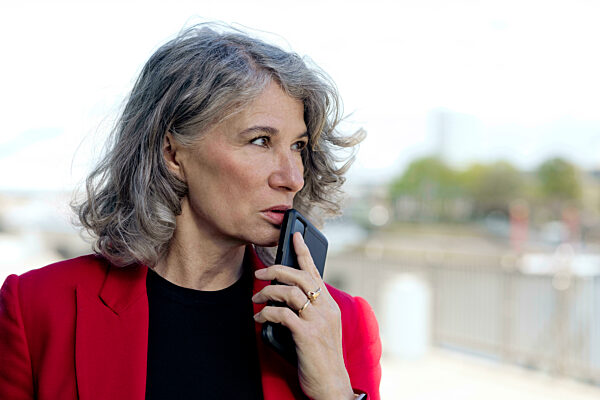 Serious businesswoman holding smart phone