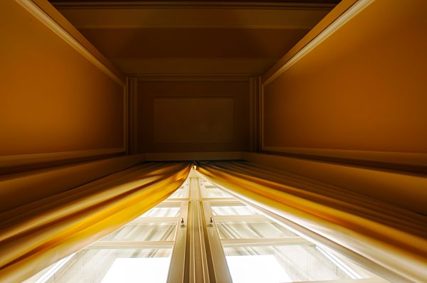 Germany, Berlin, Yellow curtains on high window