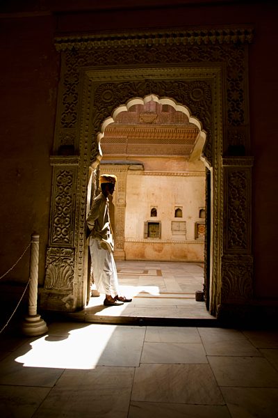 India, Rajasthan, Jodhpur, Indian man with turban standing at door in Fort