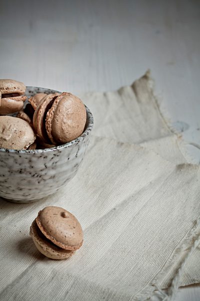 French Macarons filled with chocolate ganache in bowl