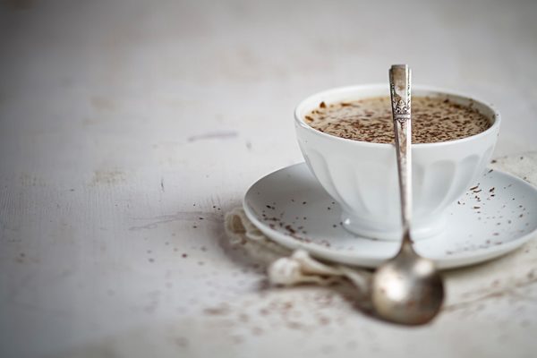Bowl of coffee sprinkled with chocolate, close up