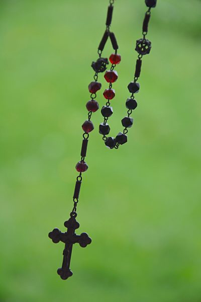 Rosary in front of blurred green background