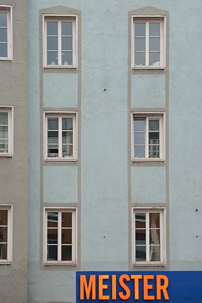 Germany, Bavaria, Munich, part of grey house front with windows and sign