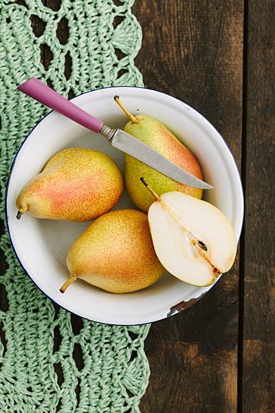 Fresh pears and a knife in a bowl