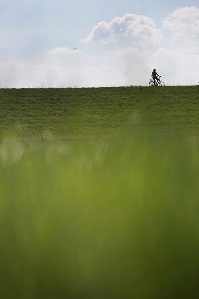 Germany, Lower Saxony, East Frisia, Langeoog, cyclist on the dike