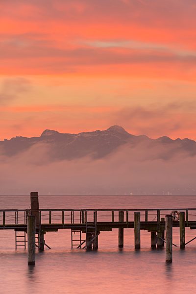 Germany, View of jetty near Haltnau in front of Swiss Alps