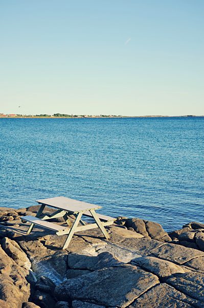 Sweden, Varberg, Bench at rocky coastline