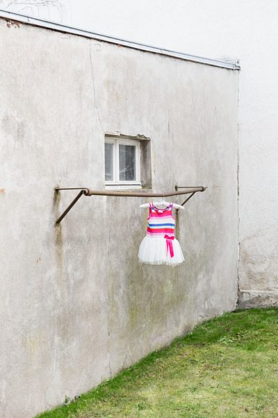 Germany, glum backyard with children's dress hanging on clothes pole