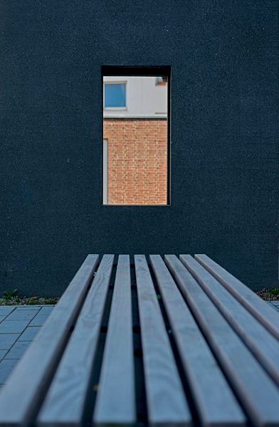 Germany, North Rhine-Westphalia, Aachen, dark facade and bench in front