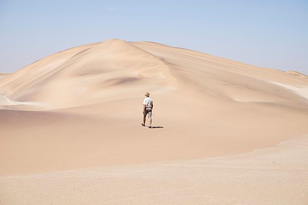 Africa, Namibia, Namib desert, Swakopmund, Dorob National Park,  guide walking on desert dune