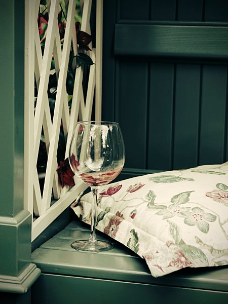 Germany, Lower Saxony, Pergola with wine glass and cushion