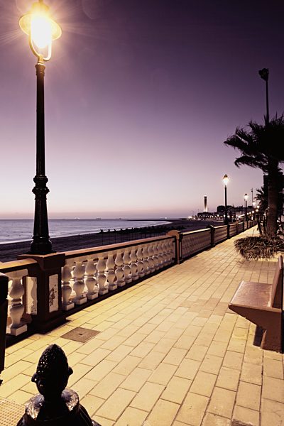Spain, Cadiz, Chipiona, Promenade and street light in the evening