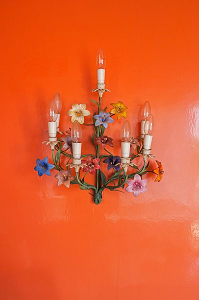 Old wall lamps hanging at glossy red wall