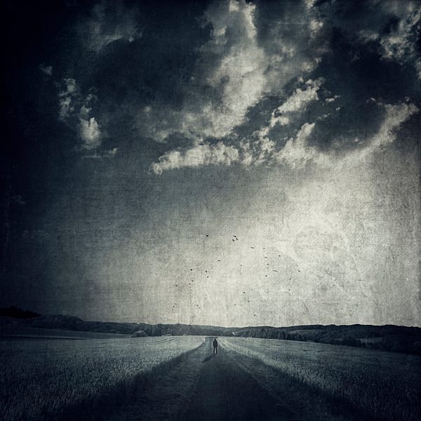 Man standing on empty countryl road