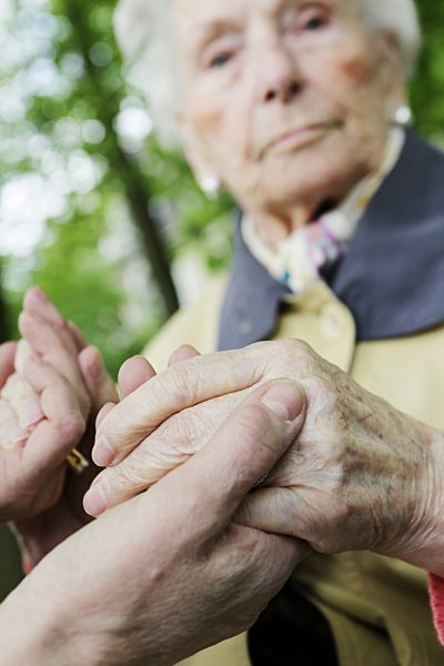 Germany, North Rhine Westphalia, Cologne, Senior woman holding hands of mature woman, close up