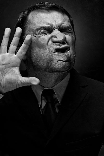 Mature man face against glass window, close up