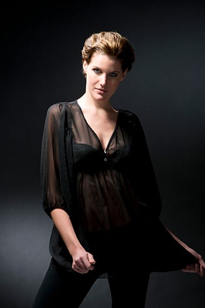 Portrait of young woman against black background