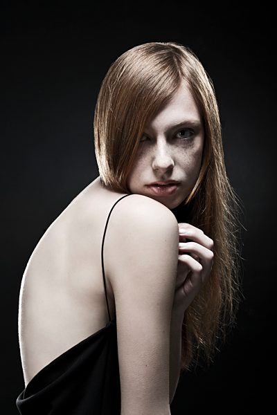 Portrait of young woman in black dress, close up