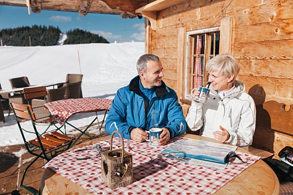 Germany, Bavaria, Winklmoosalm, Mature couple on terrace of alpine hut