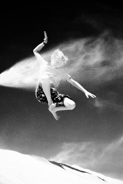 France, Boy jumping on sand