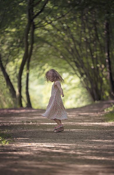 Little girl dancing on forest track