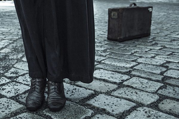 Woman standing on pavement, low section