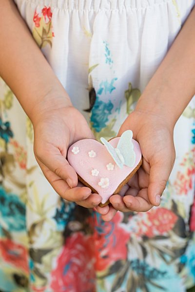 Germany, Bavaria, Girl holding heart shaped biscuit, close up