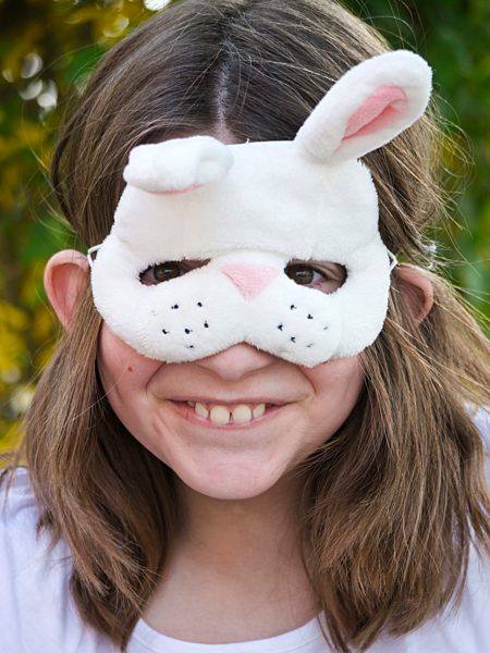 Germany, Bavaria, Close up of girl wearing easter bunny mask, smiling, portrait