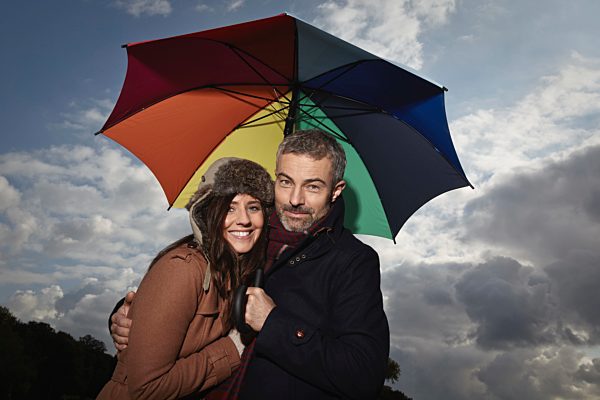 Germany, Cologne, Couple with umbrella, smiling, portrait