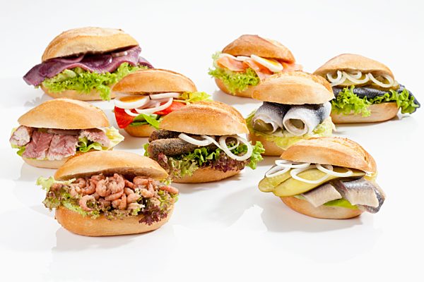 Varieties of bread rolls with fish on white background, close up