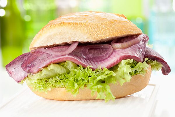 Bread roll with sherry herring and onions, close up