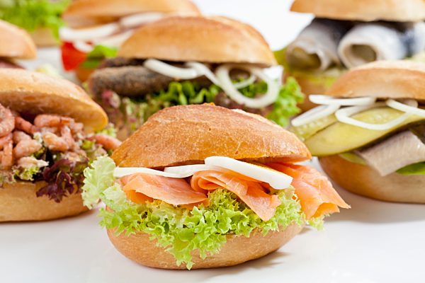 Varieties of bread rolls with fish on white background, close up