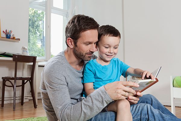 Germany, Berlin, Father and son reading book