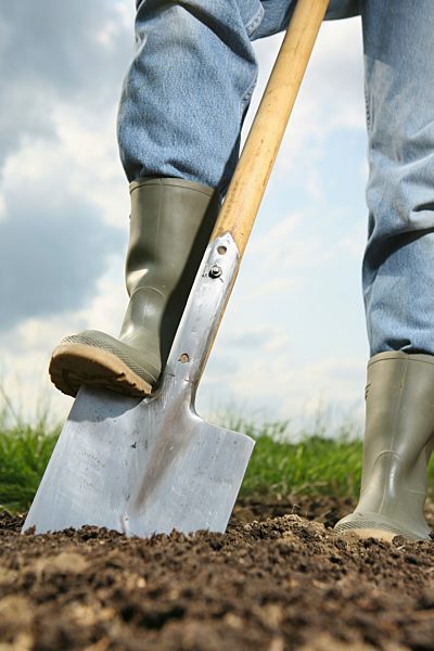 Germany, Bavaria, Human legs with spade on field
