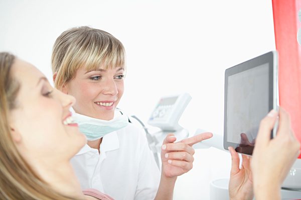 Germany, Dentist and patient with digital tablet in dental office