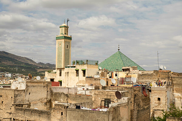 Fez skyline with mosque and traditional rooftops under cloudy sky