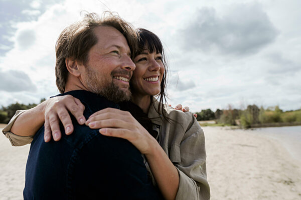 Couple embracing outdoors in nature on a windy day showing love and trust